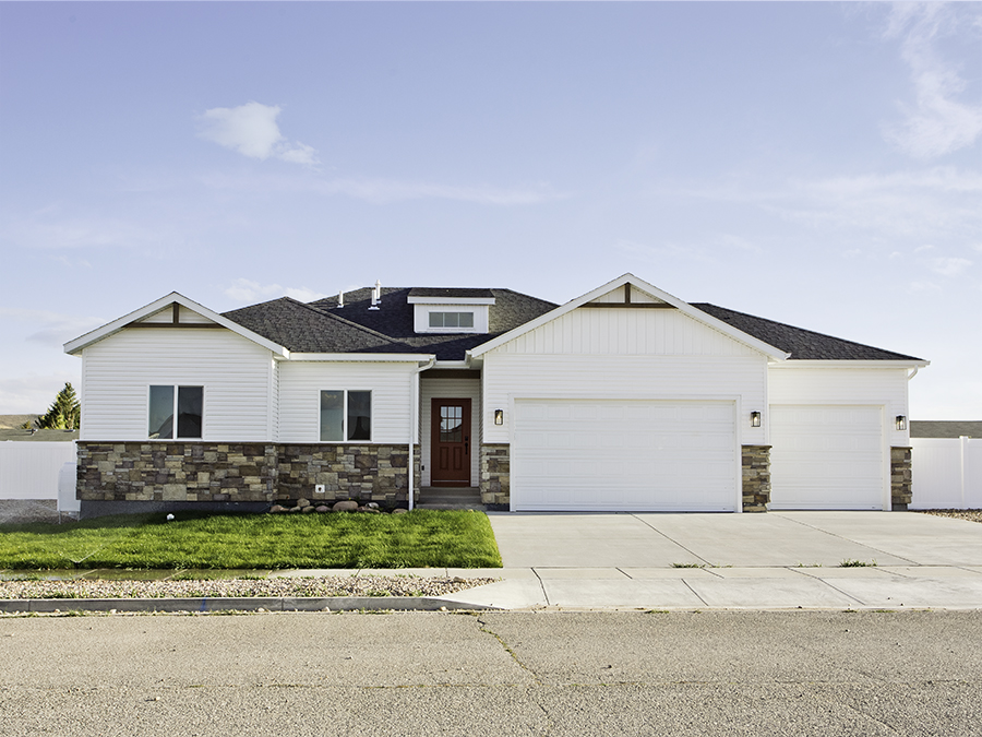 New Ranch 3-bed, 2-bath, 3-car home with unfinished basement. White siding with brown stone accents.